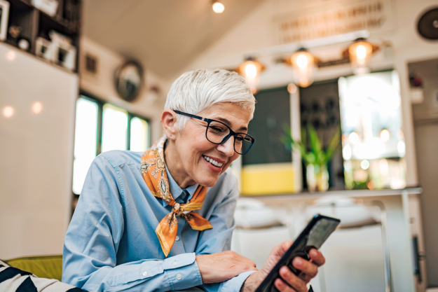Combatting-Loneliness-in-Seniors woman looks at her phone while learning about loneliness in seniors