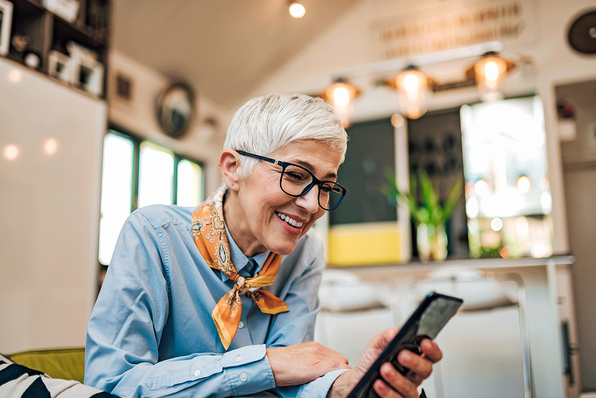 woman looks at her phone while learning about loneliness in seniors