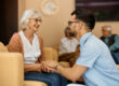 a senior woman is visited by a loved one in assisted living