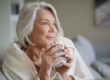 a woman enjoys a cup of tea in her new independent senior living apartment