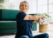an older woman practices yoga in her home