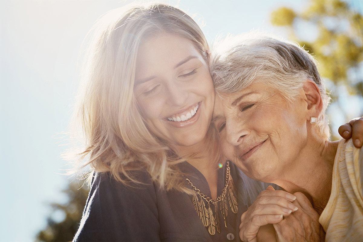 a woman smiles at her senior loved one after they choose a memory care program