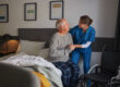 Woman helping a senior man out of bed