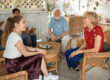Grandchildren sitting on wicker furniture set visiting with grandparents